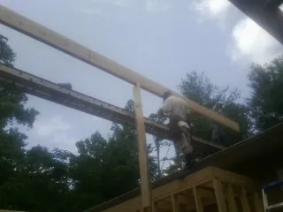 Carpenter setting a ridge beam over a new addition frame — Ice Dam Removal by Roofing Brothers in White Castle
