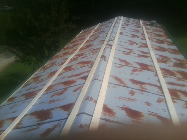 Rusted metal roof panels with new wood purlins before replacement — Storm Damage Roof Repair in White Castle by Roofing Brothers