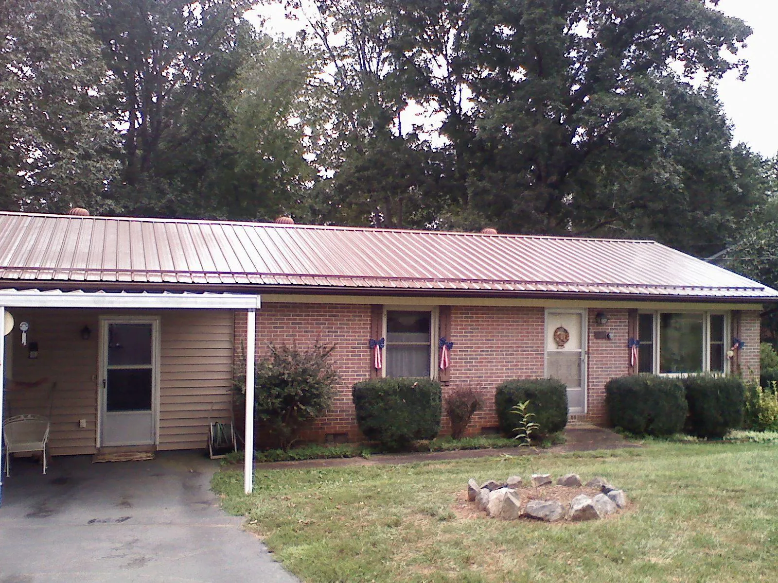 Bronze metal roof and carport on a brick ranch home — Roof Repair work by our crew in White Castle
