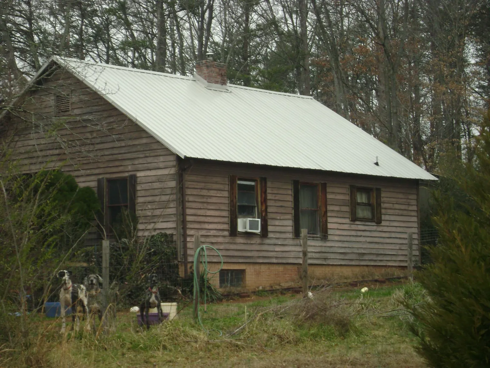 White metal roof on an old wood sided farmhouse, from a Metal Roof Installation job in White Castle